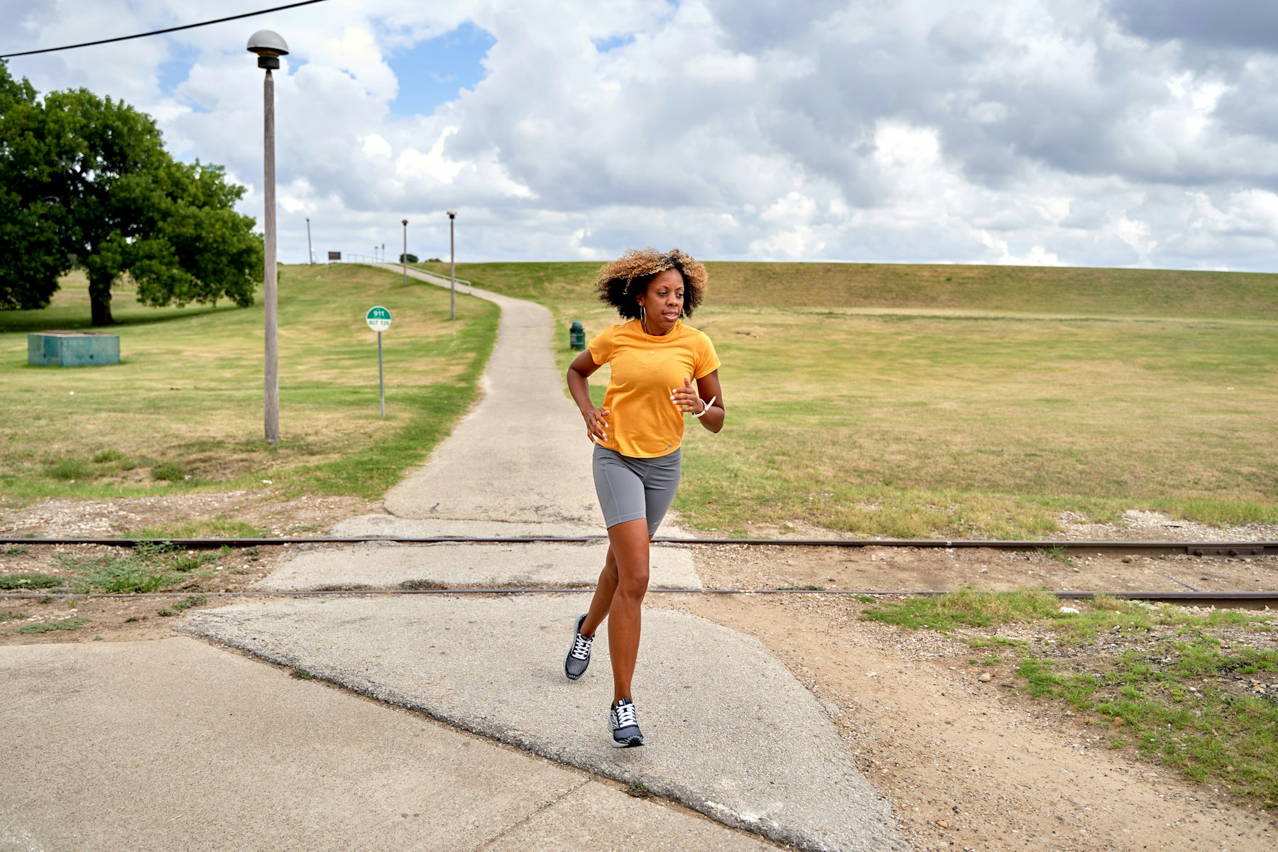 A Black woman running on an outdoor path